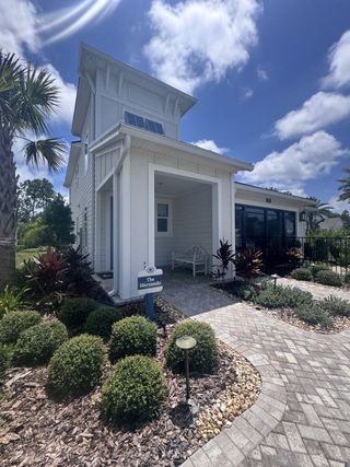 Street view A charming white home with lush landscaping in Reflections at Nocatee by Providence Homes (Nocatee, FL).