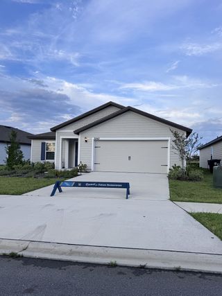 A modern gray siding home with a manicured lawn in Rolling Hills by LGI Homes (Green Cove Springs, FL).