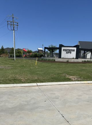 Street view Modern community entrance with landscaped greenery in Westridge Cove by Coventry Homes (Conroe, TX).