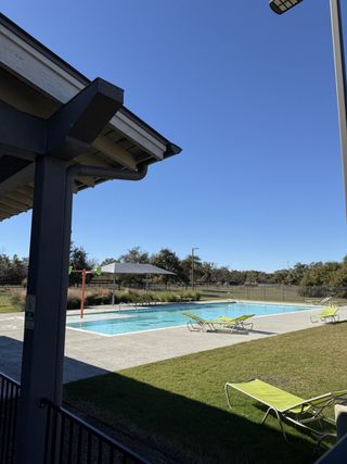 Community Amenities A refreshing pool with lounge chairs and a shaded area in Carneros Ranch by Coventry Homes in Leander, TX.