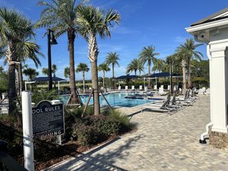 A stunning resort-style pool surrounded by lush palm trees in Summer Bay at Grand Oaks by Pulte Homes in St. Augustine, FL.