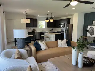 Model Home Modern open-concept living area with sleek dark cabinets, neutral tones, and stylish furnishings.