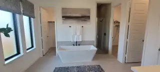 A sleek bathroom featuring a modern freestanding tub, glass shower, and neutral tones for a serene atmosphere.