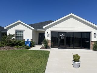 Street view Charming white home with a manicured lawn in Stonebridge North by Highland Homes of Florida (Zephyrhills, FL).