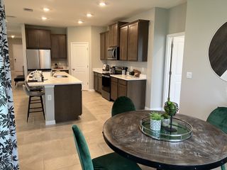 Model Home A gourmet kitchen with dark wood cabinets, stainless steel appliances, and a spacious island, perfect for entertaining.