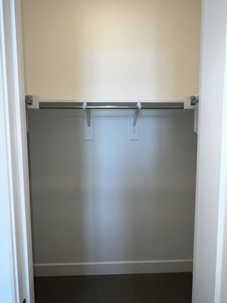 A simple, spacious walk-in closet with built-in shelving and hanging space.