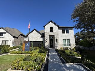 Street view A beautiful stone home with manicured landscaping in Wolf Ranch - 55' by Westin Homes (Georgetown, TX).