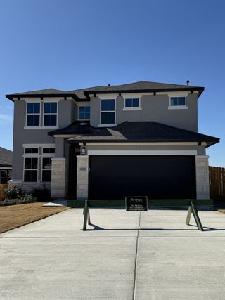 Street view A modern two-story home with a sleek design in Lakeside at Tessera on Lake Travis by Saratoga Homes (Lago Vista, TX).