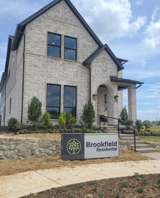 Elegant brick home with lush landscaping in The Grove Frisco by Chesmar Homes, showcasing Brookfield Residential's design.