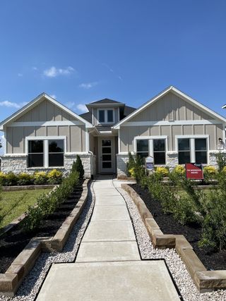 A charming modern home with a landscaped entry in Laurel Landing by Coventry Homes (Alvin, TX).