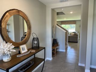 A stylish entryway with a rustic wood mirror and elegant decor, setting the tone for the home.