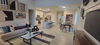 A modern open-concept living area with abstract art, cozy seating, a sleek kitchen, and a stylish dining setup.