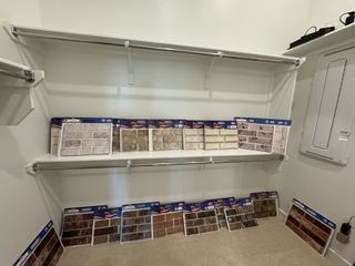 A closet with open shelves displaying various bricks and stone samples for home customization.
