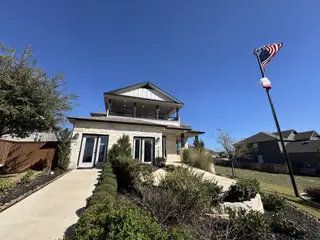 A modern home with stone accents and a well-kept path in Homestead by CastleRock Communities (Schertz, TX).