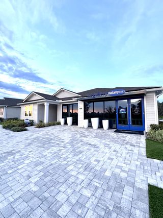 Street view A modern model home with sleek pavers in Lakes at Bella Lago by Mattamy Homes (Green Cove Springs, FL).