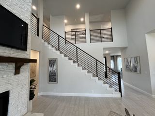 Open-concept living space with tall windows, neutral tones, and a cozy fireplace.