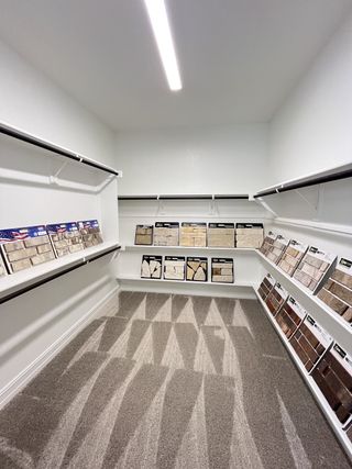 A spacious closet featuring a variety of wall and floor tile samples, illuminated by sleek modern lighting.
