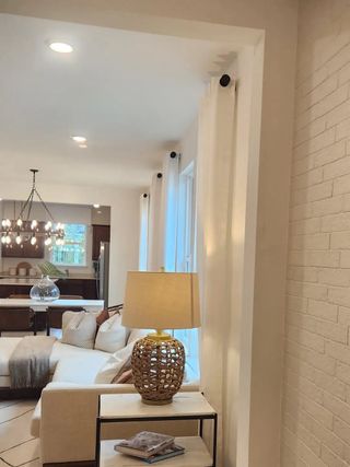 Model Home A cozy living room featuring a plush sofa, woven lamp, and elegant chandelier, exuding warmth and comfort.