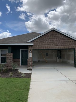 Street view A charming brick home with a spacious garage in Eastwood at Sonterra: Cottage Collection by Lennar (Jarrell, TX).