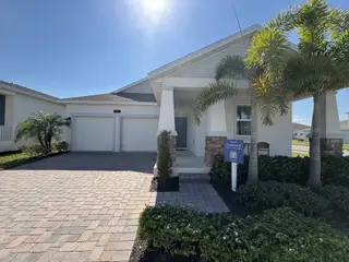 Street view A beautifully crafted home with a paved driveway, elegant finishes, and tropical landscaping in Tohoqua by Lennar (Kissimmee, FL).