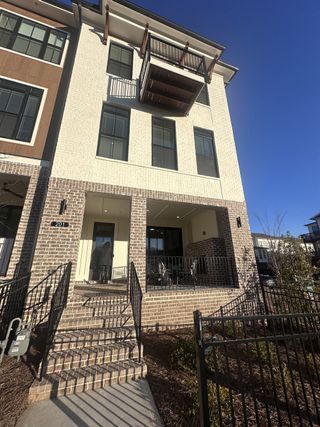 A modern brick townhouse with a charming porch in Ecco Park by The Providence Group (Alpharetta, GA).