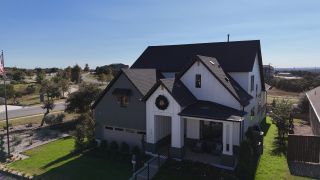 Model Home A beautiful modern farmhouse with contrasting brick and board-and-batten siding in Headwaters by David Weekley Homes (Dripping Springs, TX).