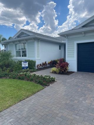 Model Home A charming white home with lush landscaping in Tradition - Cadence by Mattamy Homes (Port St. Lucie, FL).