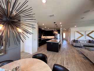 A sleek dining area and kitchen with chic lighting and high-end finishes perfect for entertaining.