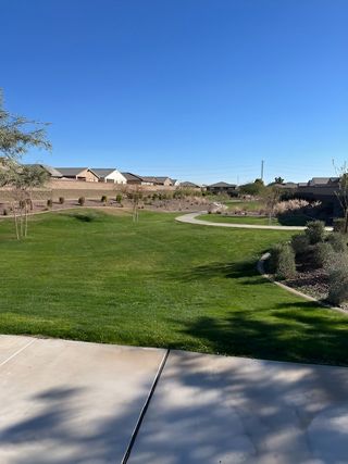 Community Amenities A scenic community park with lush greenery and a paved path in Copper Ridge - Classic Series by Meritage Homes (Maricopa, AZ).