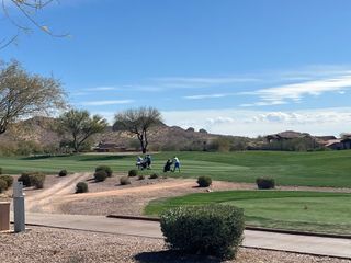 A picturesque golf course with lush greens and desert landscaping in Club Village at Superstition Mountain by Bellago Homes (Gold Canyon, AZ).