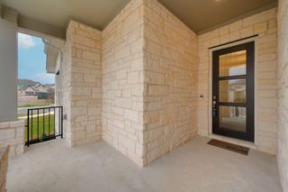 A welcoming stone entryway with a modern glass door, leading to a stylish interior space.